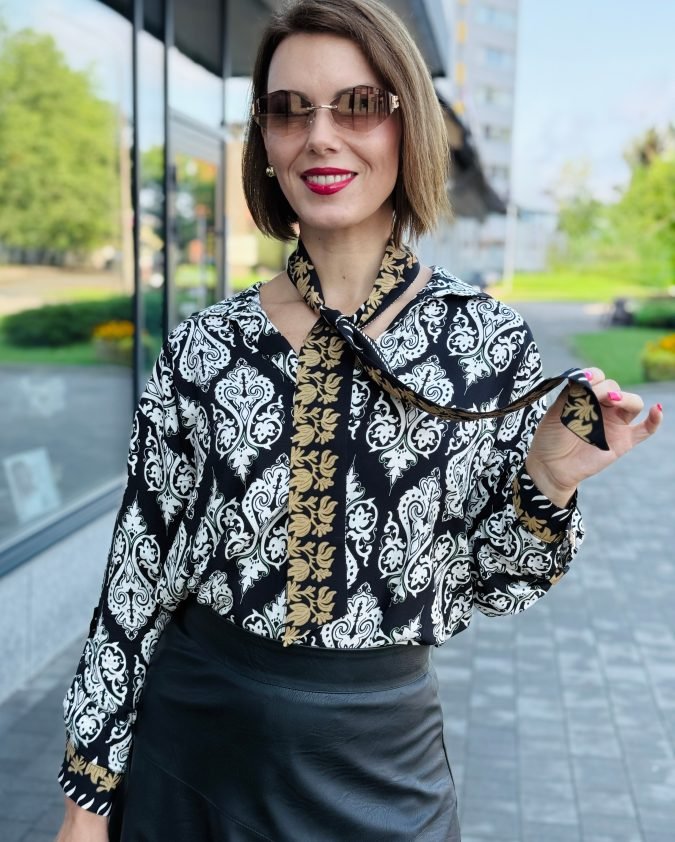 kreklveida blūze ar dekoratīvu lentu komplektā. Ornamentu rakstu un garām piedurknēm. Eleganta un sievišķīga